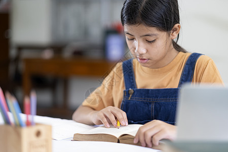 亚裔女孩在家读书做家庭功课教育作业孩子们考试办公桌课堂阅读家庭作业研究知识图片