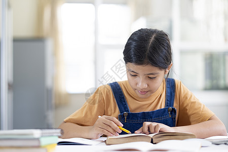 亚裔女孩在家读书做家庭功课孩子学习教育课堂瞳孔家庭作业写作女学生考试学校图片