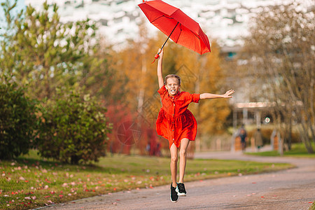 快乐的女童在红伞下欢笑情绪公园下雨橡胶彩虹乐趣幸福孩子们女孩季节图片