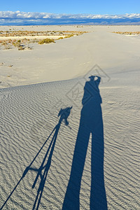 摄影师在石膏沙丘上的影子涟漪植物群蓝色干旱沙漠公园水晶侵蚀纪念碑天空图片