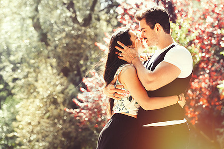 在公园里爱室外的年轻情侣 两个年轻情人之间的爱情图片