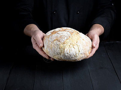男厨手握着一整包烤面包面包男人白色厨房美食乡村产品小麦黑色面包师图片
