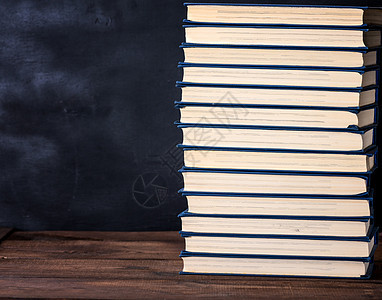 蓝色封面的大堆书卷收藏白色图书馆智慧学习学校大学棕色团体桌子背景图片