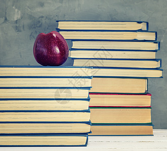 堆叠在书本上的成熟红苹果知识学习书架黄色智慧文学学校大学教科书团体图片