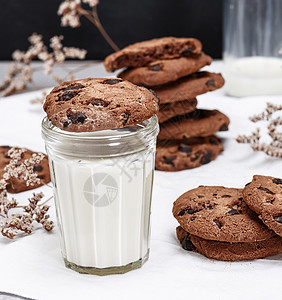 圆巧克力饼干是一个透明的有牛奶的杯子图片