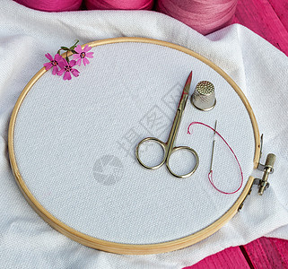 刺绣和剪刀用白织物的圆木环圈图片