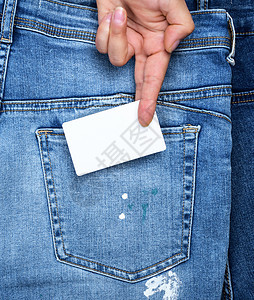 手拿着一张空白的白色长方形纸商务车裤子蓝色小样材料纺织品女性口袋衣服织物卡片图片