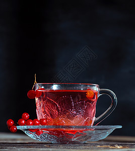 在透明的杯子里用手柄喝热生茶食物药品黑色草本红色飞碟玻璃桌子浆果饮料图片