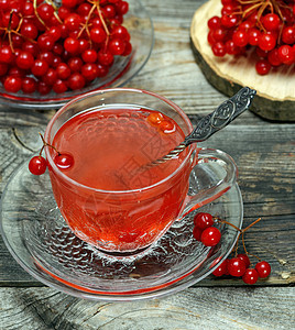在透明杯子里的热生茶芳香桌子勺子水果药品食物荚蒾木头飞碟饮料背景图片