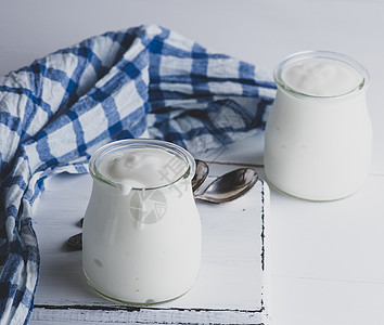 白木板上带自制酸奶的玻璃罐奶制品营养早餐玻璃餐巾饮食奶油牛奶白色食物图片