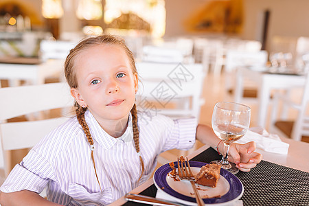 可爱的小女孩在户外咖啡厅吃早餐蜂蜜咖啡店眼睛快乐婴儿餐厅小吃金发食物桌子图片