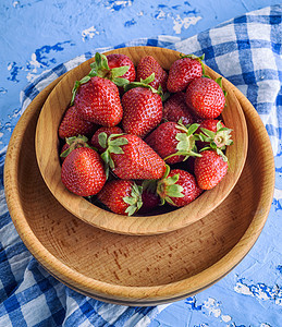 棕色木板上鲜熟的红草莓图片