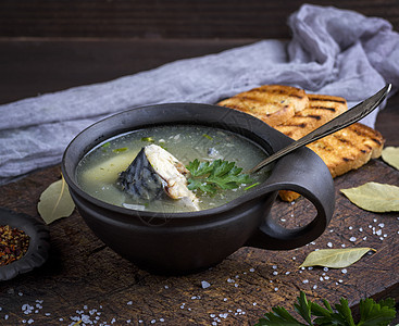 棕粘土板中的竹鱼汤食物香菜鲭鱼木头午餐绿色香料乡村棕色桌子图片