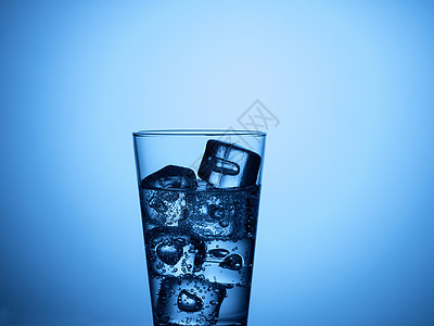 塑料瓶和加冰的玻璃杯气泡矿物饮料白色液体立方体蓝色图片
