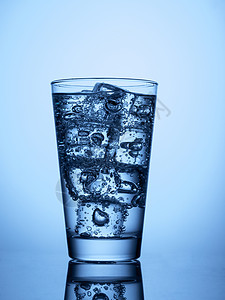 塑料瓶和加冰的玻璃杯白色气泡液体蓝色反射矿物立方体饮料图片