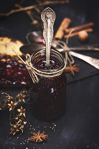 用铁勺子在玻璃罐子里的草莓果酱甜点面包食物黑色桌子乡村水果早餐红色图片
