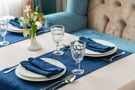 餐桌上的餐桌庆典奢华餐具派对花朵装饰食物餐巾蓝色扶手椅图片