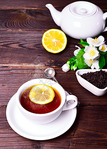 白杯茶中的黑茶饮料红色杯子美食桌子勺子液体白色盘子早餐图片
