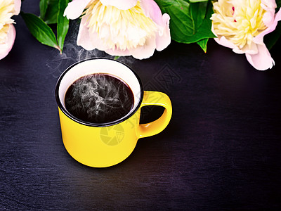 黑面上黄色杯子的咖啡图片