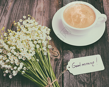 一杯热黑咖啡和一束新鲜的华丽百合花木头棕色桌子早餐花束咖啡杯咖啡杯子木板食物图片