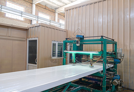 利用泡沫塑料生产三文治板的电厂制造厂建造建筑床单公司金属绝缘聚氨酯商业压力机背景图片