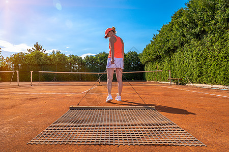 在一个户外网球场上的柳橙粘土天空游戏打扫场地扫帚玩家运动活动闲暇地面图片