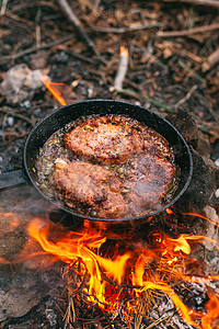 与红菜一起在露天着火的锅里煎肉 将牛排放在锅里旅游餐厅油炸菜单烹饪胡椒食物森林蔬菜香料图片