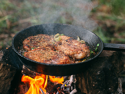与红菜一起在露天着火的锅里煎肉 将牛排放在锅里炙烤餐饮香料蔬菜迷迭香胡椒火焰森林牛肉牛扒图片
