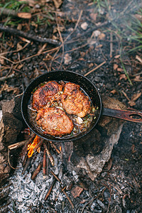 与红菜一起在露天着火的锅里煎肉 将牛排放在锅里油炸食物营火午餐厨房鱼片火焰平底锅美食旅游图片