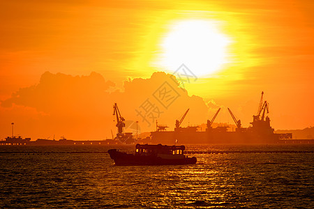 日落在海中商业天空太阳码头港口商品运输海景机械船运图片