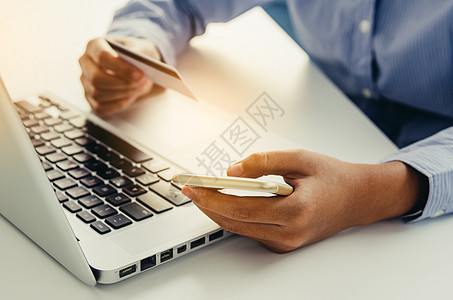持有手持信用卡和使用笔记本电脑购买订单和商业卡片电子金融互联网命令白色安全键盘购物图片