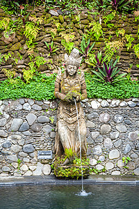 位于巴厘的池塘上的古老石头雕像喷泉图片