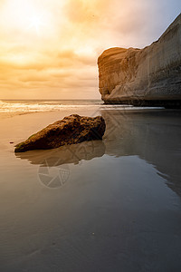 新西兰地道海滩旅游海岸海洋隧道岩石日落橙子全景晴天假期图片