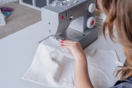 妇女在家里缝纫场缝纫时缝衣针线活衣服工人主妇作坊手工纺织品机器制造业女士图片