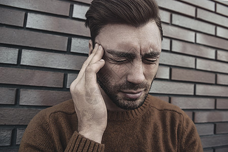 男性情绪狂躁的头部大喊大叫 对某人或某事感到恼火 表达消极的情绪 孤立在砖墙背景之上白色痛苦尖叫棕色偏头痛疼痛压力成人图片