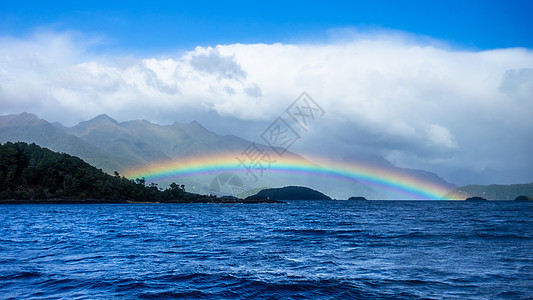 新西兰马纳普里湖彩虹阳光荒野全景山脉蓝色涟漪丘陵白色天空图片
