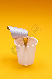 橙色背景的勺子空清酸奶杯厨房牛奶食物奶制品塑料早餐奶油白色饮食橙子图片