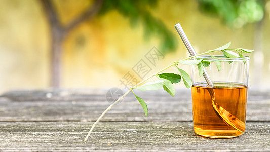 旧木木板上的花叶茶香料花草杯子玻璃树叶药物草本植物保健卫生草药图片