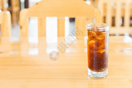 木制桌上用玻璃冰块加冰的可口可乐汽水图片