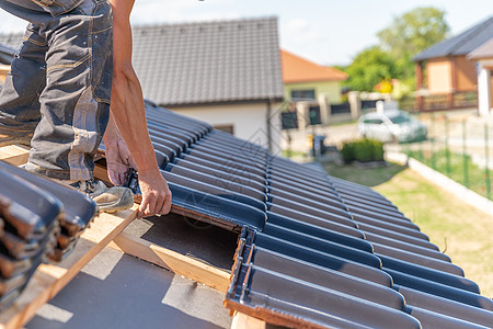 家庭房屋用陶瓷发射的瓷砖制屋顶生产施工建筑男人工人工作山墙防水躯干劳动装修图片