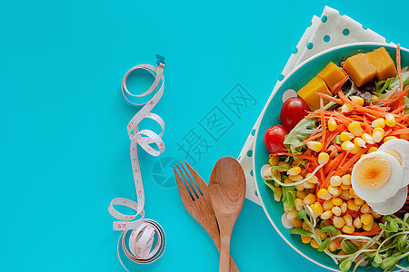 新鲜沙拉蔬菜 配有煮鸡蛋 计量胶带 木勺子和叉美食损失饮食健康磁带控制食物盘子重量养分图片