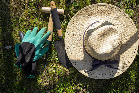 配戴手套和花园工具的草防晒霜图片