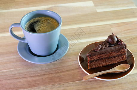 巧克力蛋糕和一杯咖啡放在木桌上的咖啡咖啡店巧克力可可桌子小吃糕点甜点杯子奶油美食图片