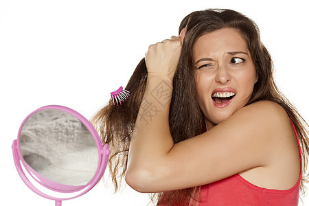 年轻女人梳理头发有问题呀女士成人黑发女性情绪化刷子压力疼痛鬼脸梳子图片