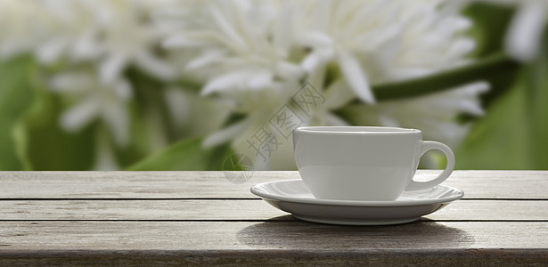 白色花朵 木木板桌树上的咖啡杯图片