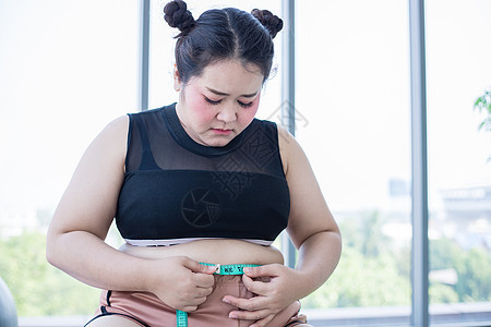 亚裔超重妇女测量脂肪层 在Hom带腰绳监视器组织腰部磁带健身房身体饮食美丽肌肉卡尺图片