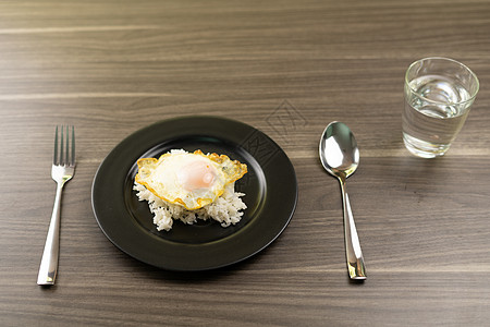 黑盘上白米饭上的炸鸡蛋 一杯咖啡水饮食美食木头油炸热带盘子食物黑色烹饪餐厅图片