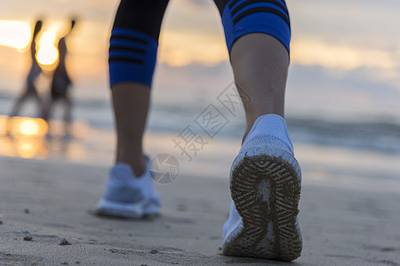 日出时在沙滩上跑的女子 在鞋上紧贴慢跑女孩海岸速度女士护理运动员日落天空海滩图片