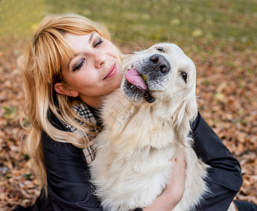 金发金发女人抱着她的猎犬公园女士拥抱朋友小狗女性公共公园动物女子成人图片