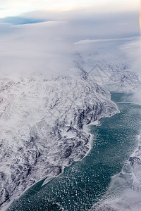 格陵兰的冰盖与冷冻的山峰和河流空中观察图片